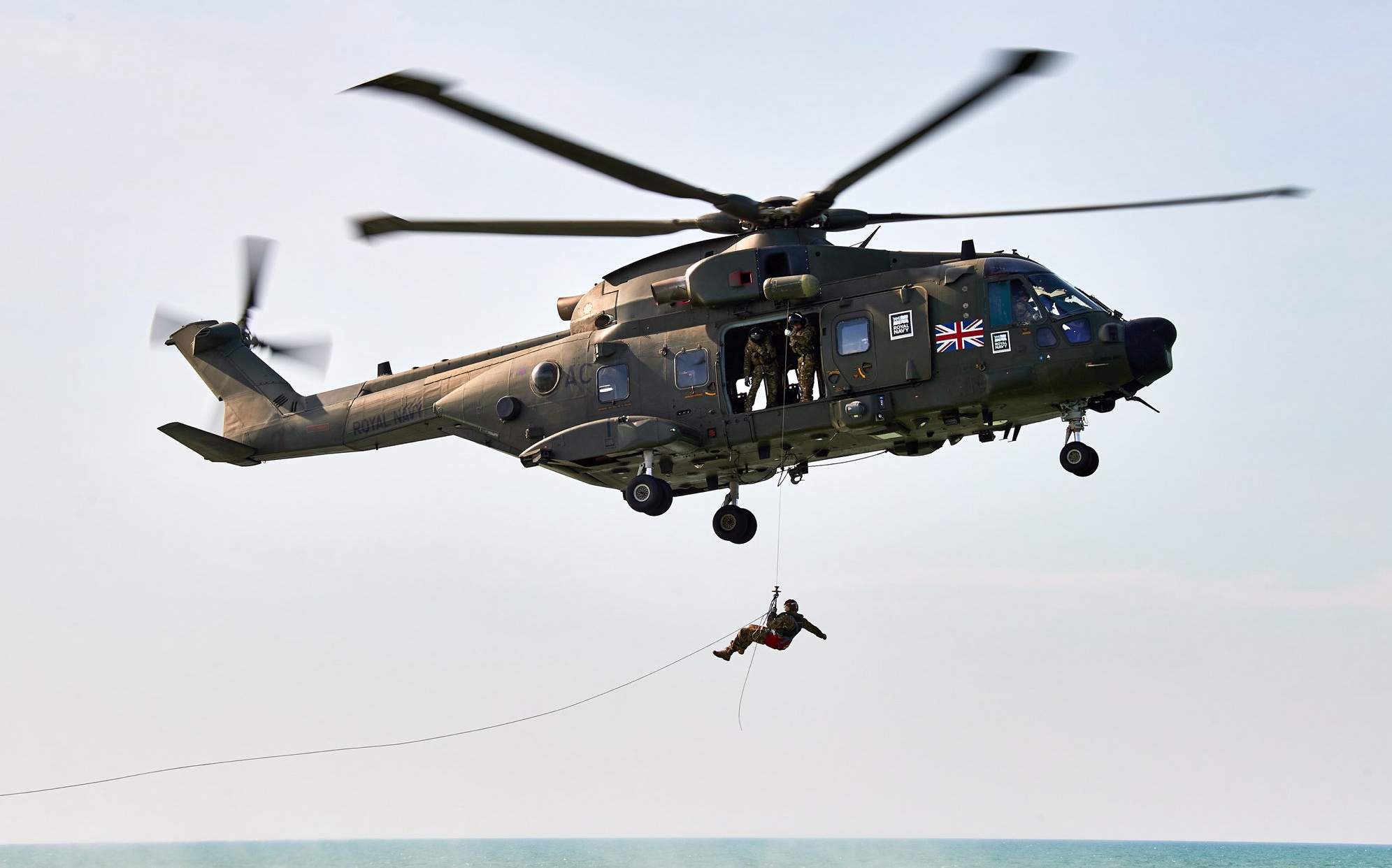 Merlin helicopter winching a Royal Marine